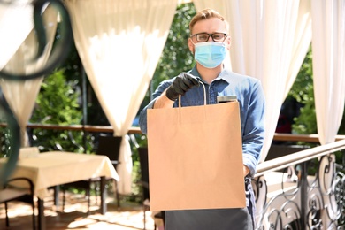 Waiter with packed takeout order in restaurant. Food service during coronavirus quarantine