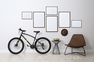 Stylish room interior with empty posters on light wall. Mockup for design
