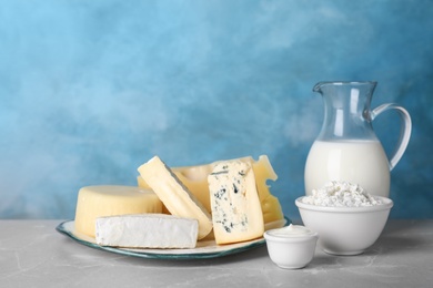 Fresh dairy products on table against color background