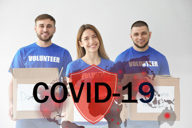 Volunteers uniting to help during COVID-19 outbreak. Group of people with donations on light background, shield and world map illustrations