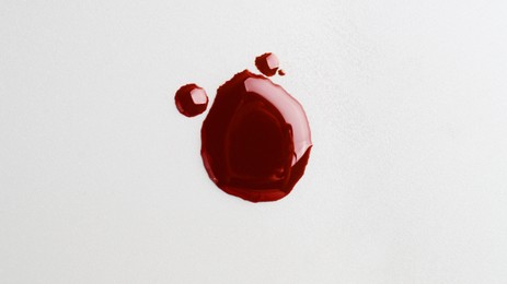 Photo of Drops of blood on grey background, top view