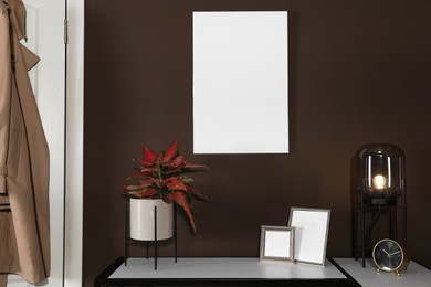 Stylish hallway interior with empty canvas on brown wall. Mockup for design