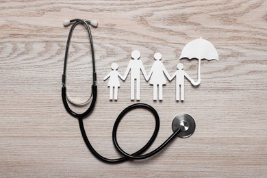 Paper family cutout and stethoscope on white wooden background, flat lay. Insurance concept
