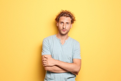 Young man in casual clothes posing on color background