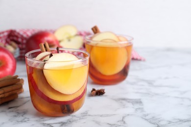 Aromatic hot mulled cider on white marble table. Space for text