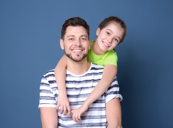 Dad and his daughter hugging on color background. Father's day celebration