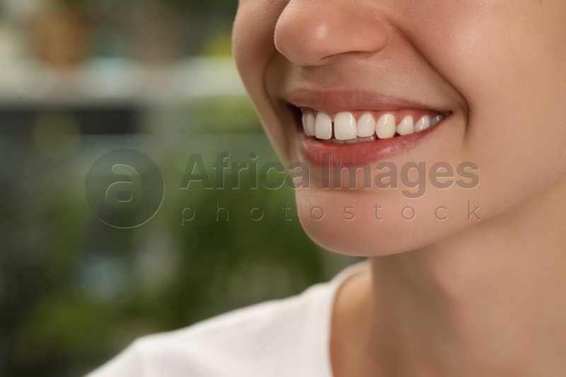 Woman with diastema between upper front teeth on blurred background, closeup