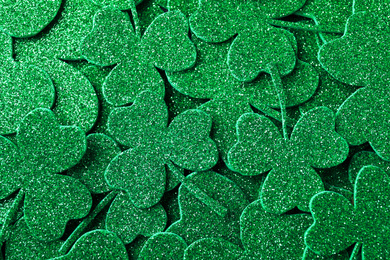 Glitter green clover leaves as background, top view. St. Patrick's Day celebration