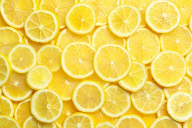 Many fresh juicy lemon slices as background, top view