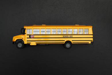 Yellow school bus on black background, top view. Transport for students