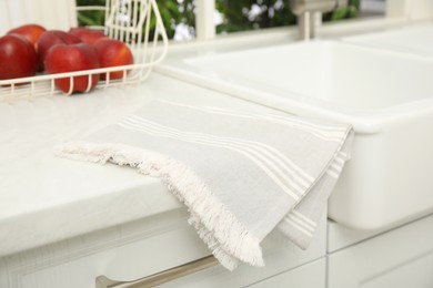 Clean towel near white sink in kitchen