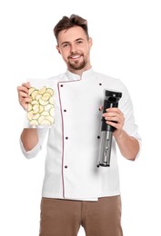 Smiling chef holding sous vide cooker and zucchini in vacuum pack on white background