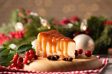 Photo of Tasty caramel cheesecake and Christmas decorations on table