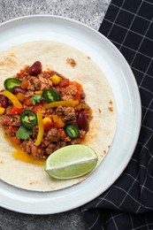 Tasty chili con carne with tortilla on grey table, flat lay
