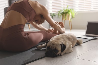 Woman with dog following online yoga class at home