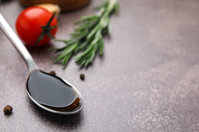 Photo of Organic balsamic vinegar and cooking ingredients on grey table, closeup. Space for text