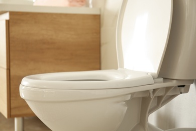 White toilet bowl in modern bathroom interior, closeup view