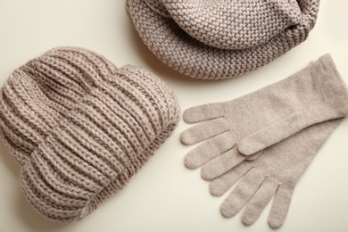 Stylish gloves, scarf and hat on beige background, flat lay