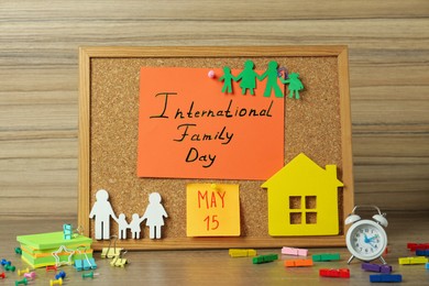 Photo of Happy Family Day. Composition with cork board and stationery on wooden table