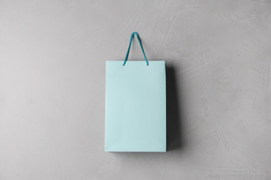 Paper shopping bag hanging on grey wall