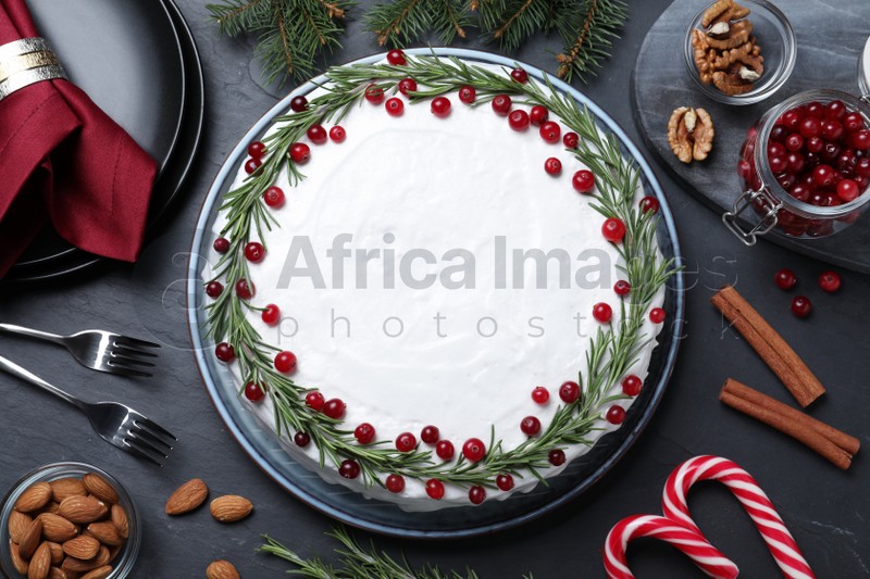 Photo of Flat lay composition with traditional Christmas cake and different ingredients on dark grey table