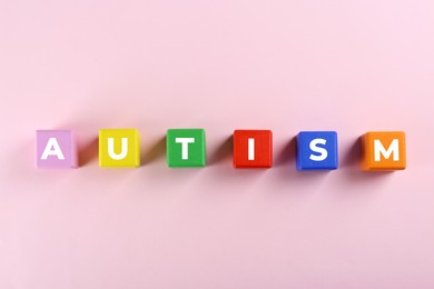 Word Autism made with colorful cubes on white background, top view