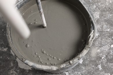 Mixing concrete in bucket indoors, closeup view
