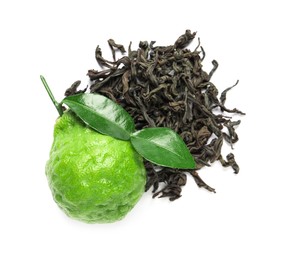 Pile of dry bergamot tea leaves and fresh fruit on white background, top view