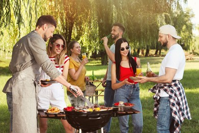 Group of friends having barbecue party in park