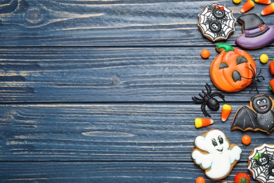 Tasty cookies and sweets for Halloween party on blue wooden table, flat lay. Space for text