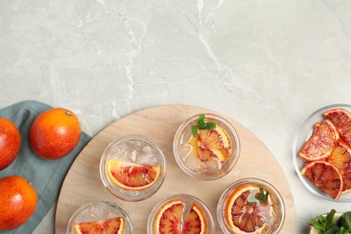 Delicious refreshing drink with sicilian orange on light grey marble table, flat lay. Space for text