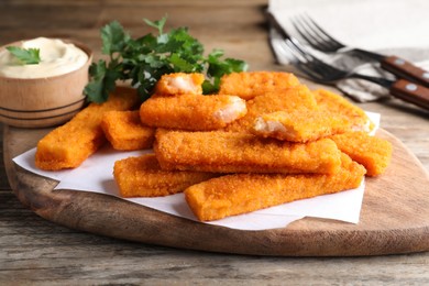Tasty fresh fish fingers served on wooden table