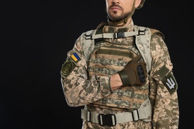 Photo of Soldier in Ukrainian military uniform on black background, closeup