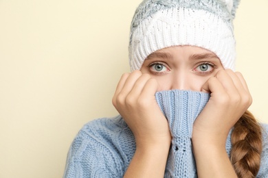 Image of Young woman wearing hat suffering from fever on light background, space for text. Cold symptoms
