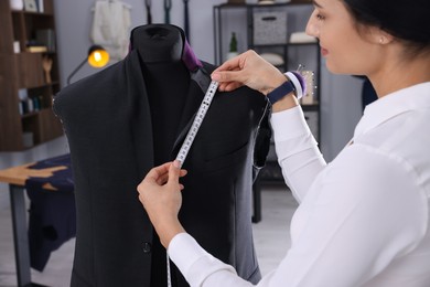 Photo of Professional dressmaker making suit jacket in atelier