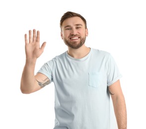 Happy young man waving to say hello on white background