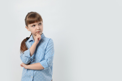 Pensive little girl on white background, space for text. Thinking about answer to question
