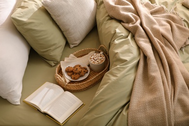 Cup of drink, cookies and book on bed with new pistachio linens