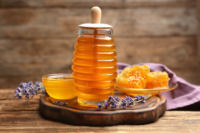 Photo of Tasty honey and lavender flowers on wooden table