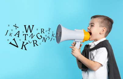 Cute funny boy with megaphone and letters on light blue background. Speech therapy concept