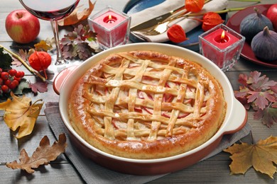 Delicious homemade apple pie and autumn decor on wooden table. Thanksgiving Day celebration