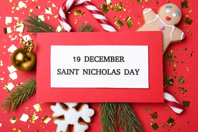 Card with text 19 December Saint Nicholas Day and festive decor on red background, flat lay