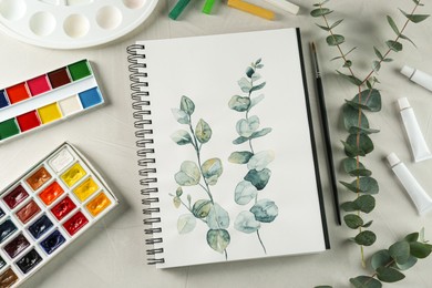 Flat lay composition with beautiful drawing of eucalyptus branches on white table