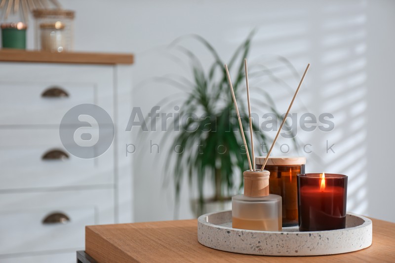 Air reed freshener and candles on table in living room. Space for text