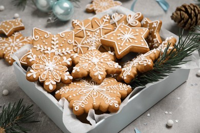 Tasty Christmas cookies and festive decor on light grey table, closeup
