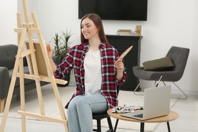 Photo of Woman learning to paint with online course at home. Time for hobby