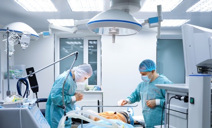 Photo of Doctor preparing patient for surgery in operating room