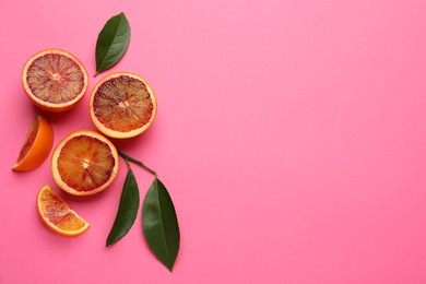 Ripe sicilian oranges and leaves on pink background, flat lay. Space for text