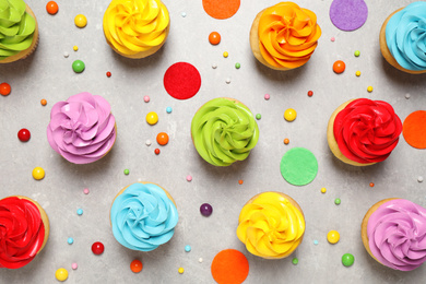 Colorful birthday cupcakes on light grey table, flat lay
