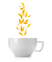 Beautiful calendula petals falling into cup of freshly brewed tea on white background